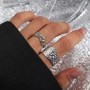 Close-up of double-layered lava texture rings and irregular hollow chain design on finger