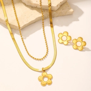 Detail of gold daisy jewelry set with double-layer necklaces and matching flower earrings