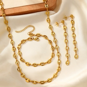 Close-up of gold coffee bean link jewelry set with necklace, bracelet and earrings