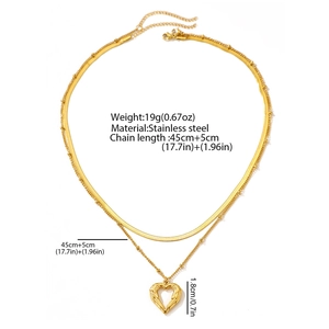 Détail du collier à deux couches en acier doré avec pendentif cœur et chaîne serpent