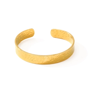 Minimalist wide open gold cuff bracelet featuring a textured ripple pattern on white background