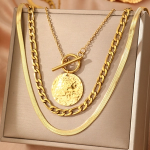 Three-layer gold stainless steel necklace with flat snake, Figaro chains and hammered pendant