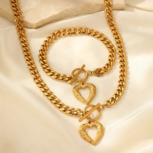 Détail d'un ensemble de bijoux gourmette 18K avec pendentif cœur et fermoir OT