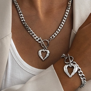 Détail du collier et bracelet chaîne cubaine argentée avec pendentif cœur et fermoir T