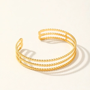 Detail view of the gold three-row beaded open cuff bracelet with minimalist geometric design