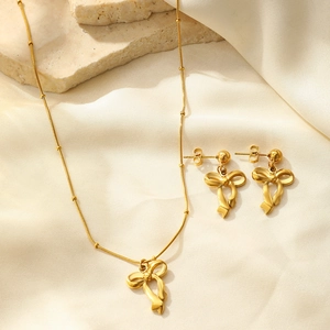 Détail d'un ensemble de bijoux nœud doré 18 carats avec collier et boucles d'oreilles