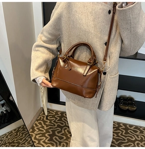 Brown glossy leather Boston bag with dual handles and bronze hardware detail