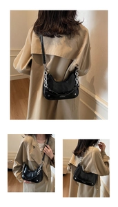 Détail du sac croissant en cuir verni noir avec chaîne argentée et logo de marque
