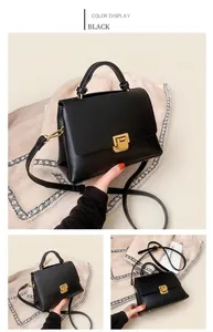 Détail d'un sac à main en similicuir noir avec fermoir métallique doré et poignée