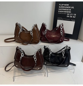 Détail de quatre sacs demi-lune vintage en cuir avec chaîne argentée et rivets