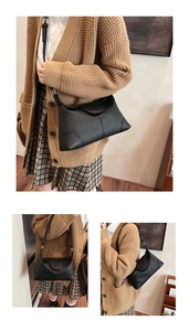 Close-up of black lychee-grain leather shoulder bag with vintage triangle stitching detail