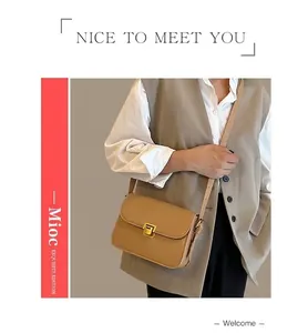 Detailed view of beige crossbody bag with adjustable strap and gold metal buckle on model