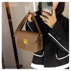 Detail of vintage brown leather crossbody bag with adjustable strap and golden buckle