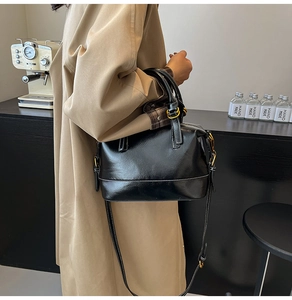 Detail der schwarzen Vintage-Boston-Tasche aus Öl-Wachs-Leder mit weißen Nähten und Gold