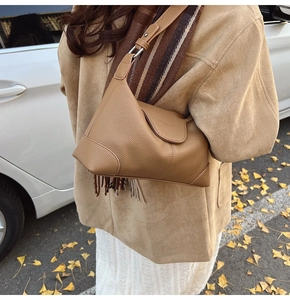 Close-up of brown lychee grain leather shoulder bag with FASHION & BAGS embossed lettering