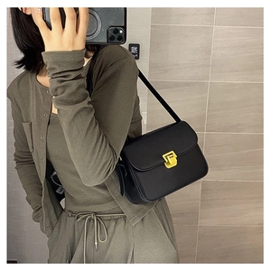 Mirror selfie showing a black vintage leather crossbody bag with a gold square buckle