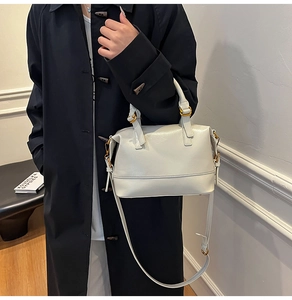 Close-up of cream oil-wax leather texture and gold metal hardware on the Boston bag