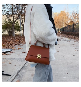 Sac à main en cuir marron avec rabat structuré et fermeture par bouton-poussoir en métal