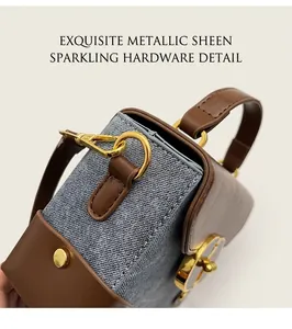 Detail of blue denim and brown leather handbag with luxury gold metallic hardware lock