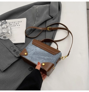 Detailed close-up of blue denim and brown leather patchwork small square crossbody bag