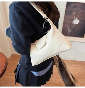 Detail of off-white lychee grain leather handbag showing stitching and texture