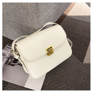Chic cream leather flap crossbody bag with gold square buckle on a stylish home background
