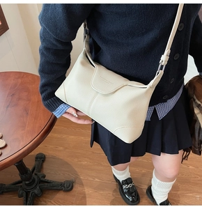 Detail of off-white lychee leather shoulder bag with logo and adjustable thin strap