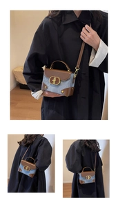 Detail of blue denim and brown leather crossbody bag with vintage golden metal buckle