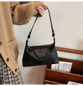 Detail of black lychee grain leather shoulder bag with Fashion & Bag embossed logo
