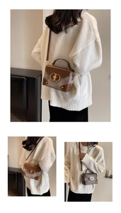 Close-up of contrast stitching, wool fabric texture, and gold metal clasp on a flap bag