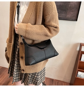 Close-up of black lychee grain leather handbag with reinforced stitching detail