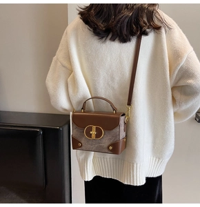 Detail of trendy small square bag in brown leather and grey wool being worn by a model