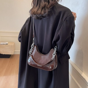 Dark brown crescent shoulder bag in glossy patent leather with silver chain strap