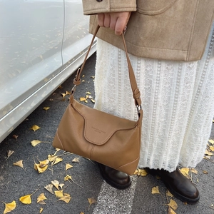 Brown litchi grain leather shoulder bag with vintage flap design and branding