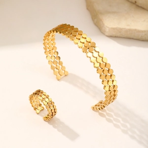 Close-up of 18K gold-plated stainless steel cuff bracelet and ring set with dot pattern