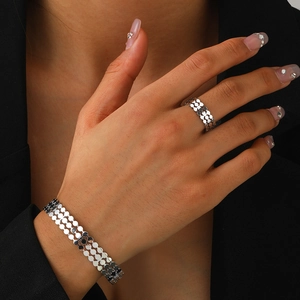 Close-up of polished silver ring and bracelet set with segmented ring-link design on model