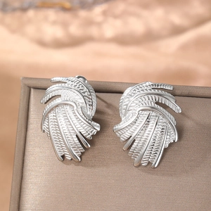 Abstract silver swirl earrings with detailed feather texture on elegant silk background