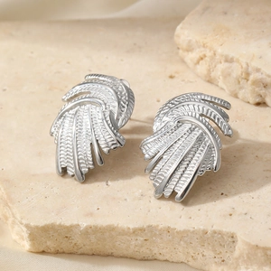 Vintage silver vortex swirl earrings with brushed feather texture on a stone plate