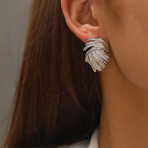 Close-up of vintage irregular swirl earrings with intricate textured silver plating