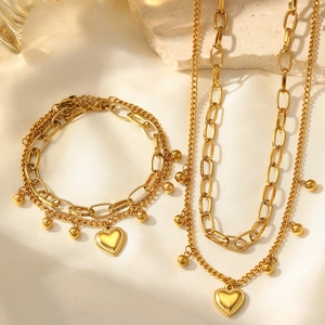 Détail de la parure collier et bracelet double couche dorée avec pendentif cœur