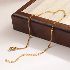 Classic golden bead chain anklet featuring a polished metal finish and lobster clasp
