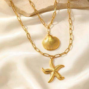 Détail du collier bohème doré avec pendentifs étoile de mer et coquillage sur soie