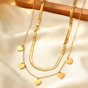 Close-up of 18k gold double-layered necklace with snake chain and heart pendants