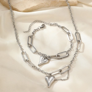 Parure minimaliste en acier inoxydable avec pendentifs cœur sur fond de satin