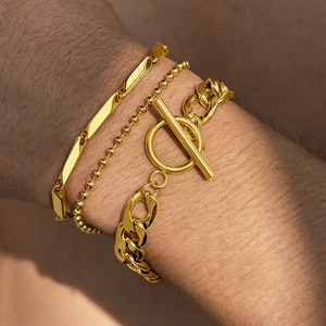 Detail of three-piece gold-plated stainless steel bracelet set with OT toggle clasp