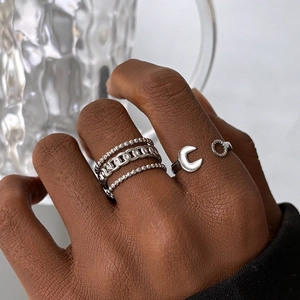 Detail view of silver layered chain rings and moon gear open ring on hand set