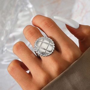 Close-up of quilted silver ring with beaded edge detail worn on woman's finger