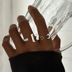 Detail of silver industrial rings with wrench and gear designs on a female hand