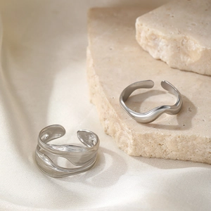 Minimalist silver adjustable wavy rings set with irregular texture on silk background