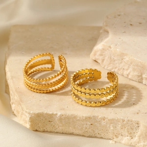 Detail of adjustable triple-layer gold stainless steel rings with beaded and woven textures